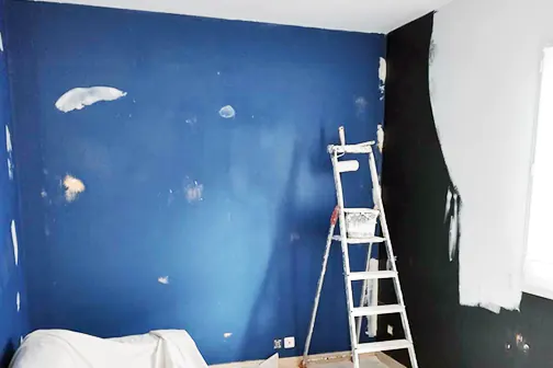 Peinture en cours d'un mur bleu